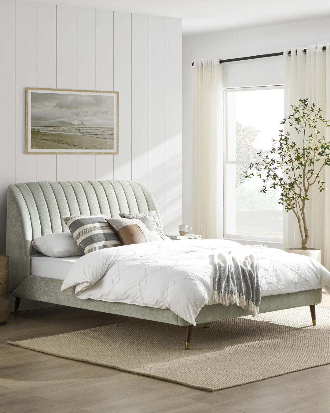 Angled view of the sage green velvet bed with wooden legs