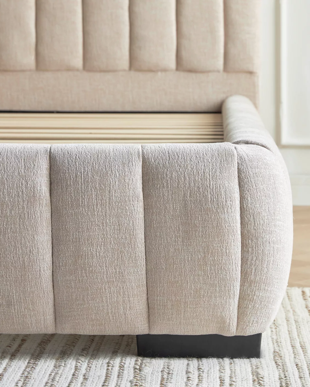 Close-up corner detail of Dunlyn bed’s vertical panel upholstery and fabric texture.