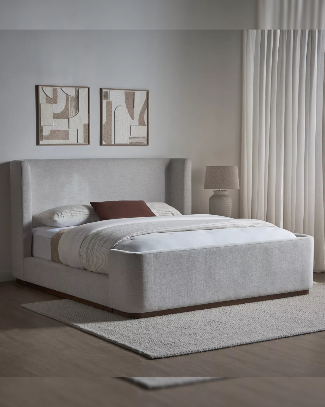Angled room view of the Elcroft bed styled with pillows and wall art in a modern interior