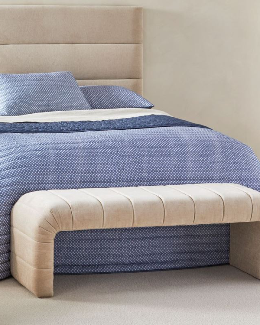 Marcroft footstool viewed from angle showing sculptural arched base and soft corners