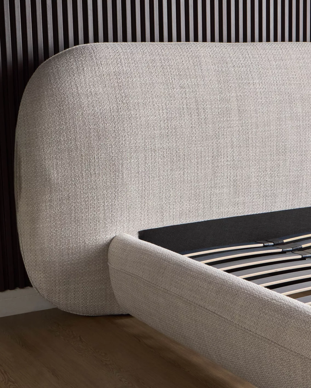 Detail showing the curved edge and fabric texture of Oakdale's headboard