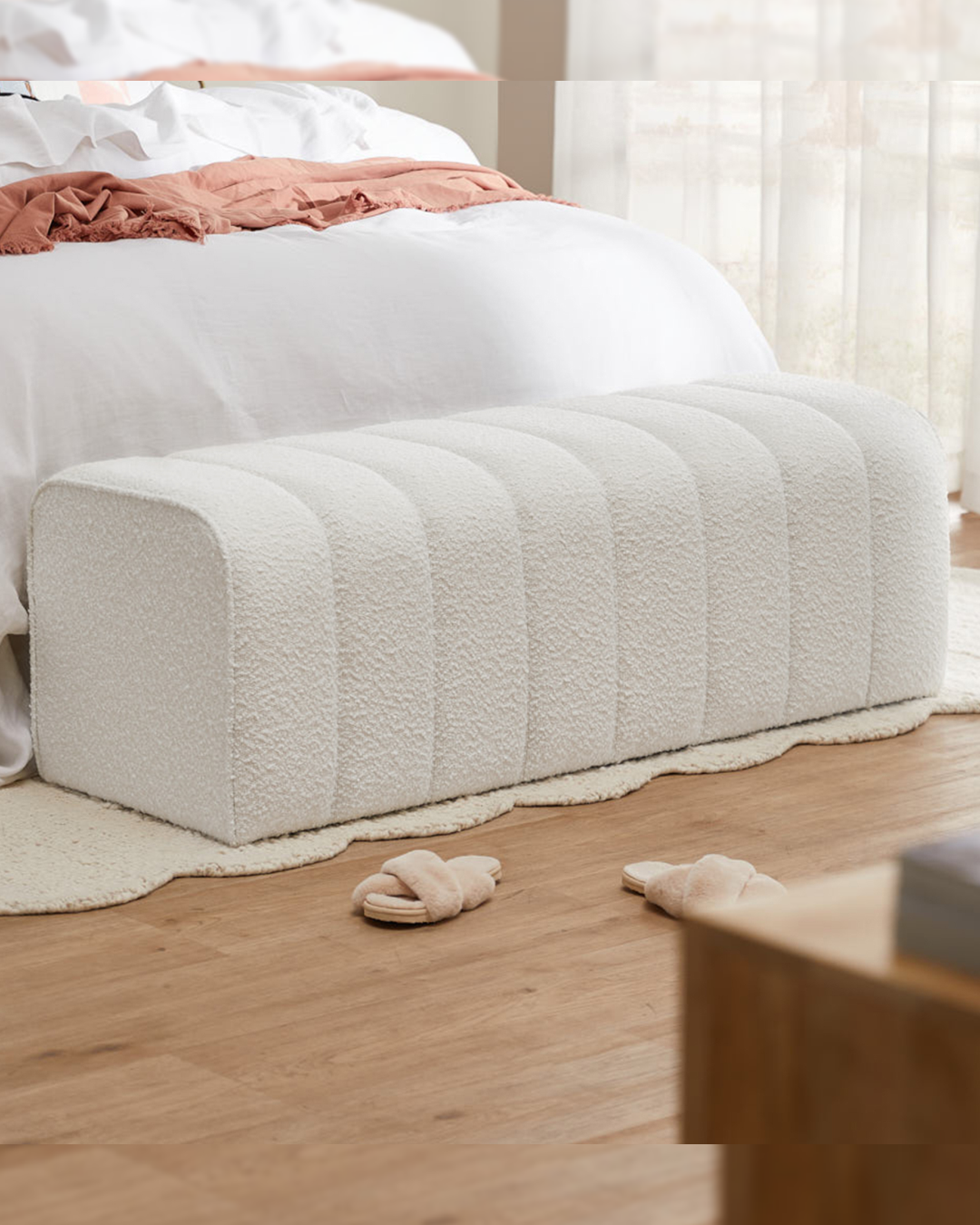 Silgrove minimal bedroom style footstool placed at the end of a white bed on neutral rug.