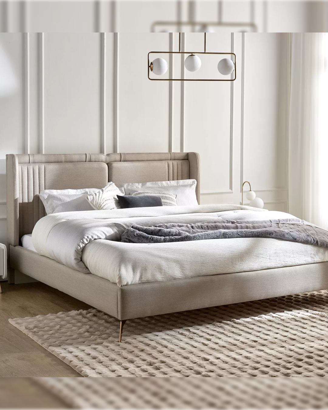 Angled side view of the Velgate elegant high curved wingback bed in a soft neutral setting