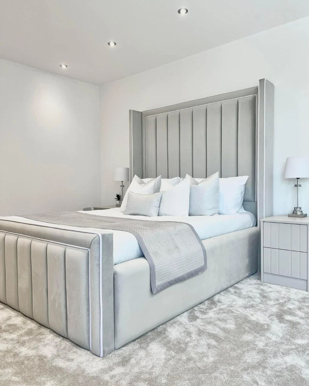 Angled side shot of the modern padded bed design in silver grey