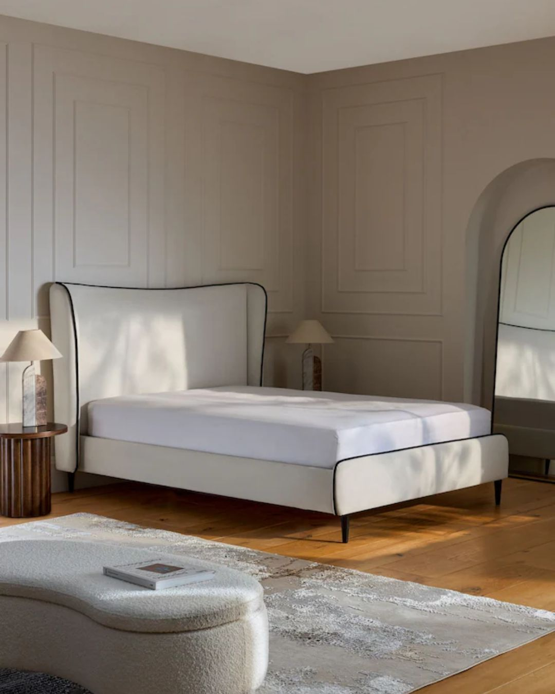 Ivory padded bed styled in a modern bedroom interior