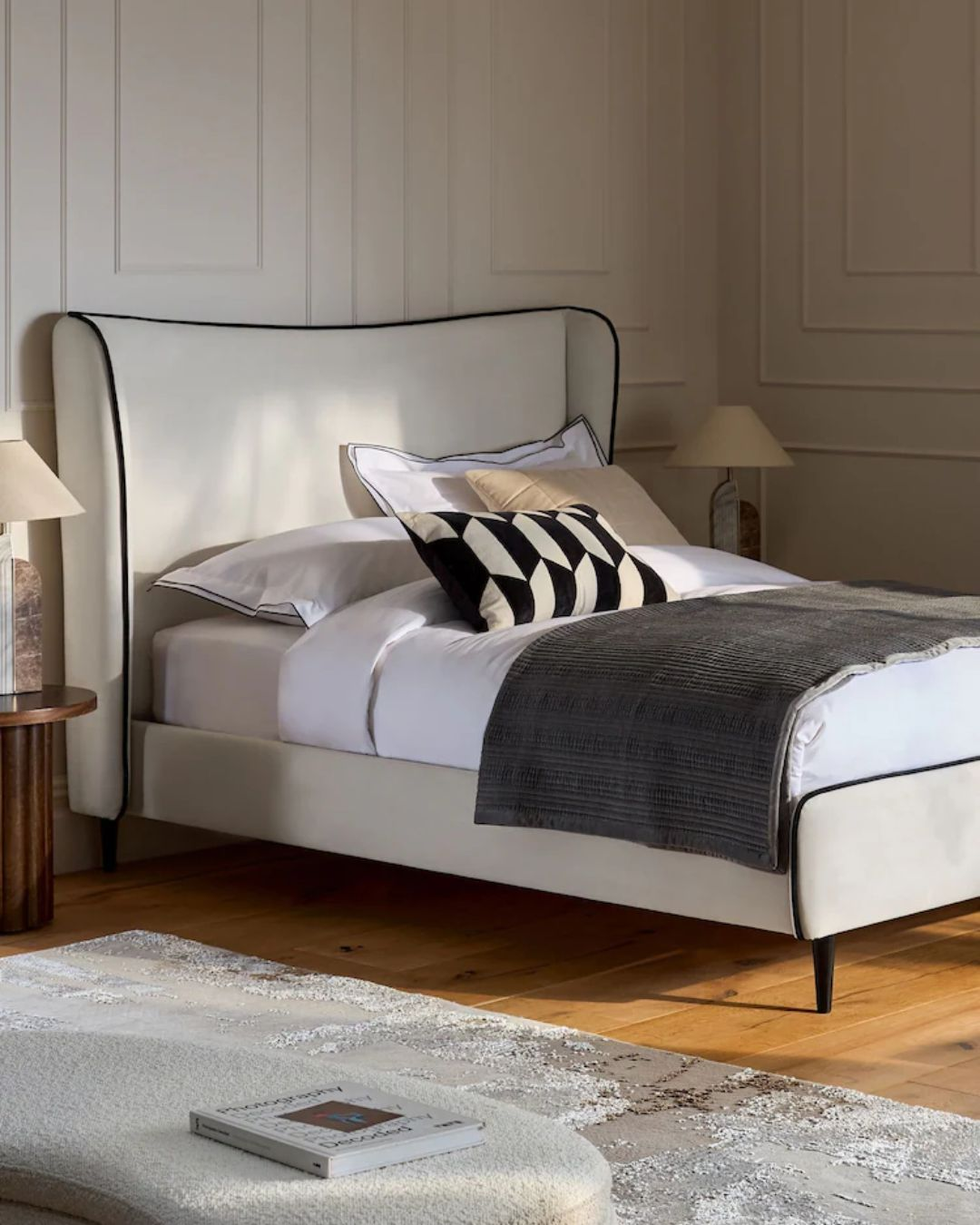 Angled view showing curved wingback bed silhouette