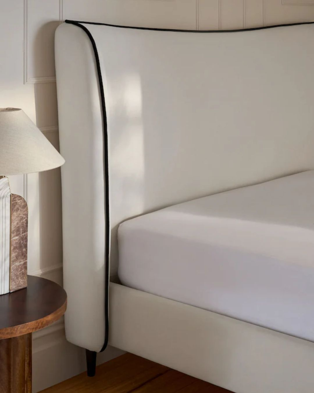 Sculptural headboard bed with soft curves and black trim