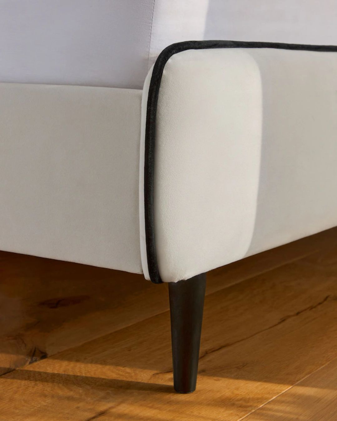 Tapered black legs and lower frame of the UK handmade bed